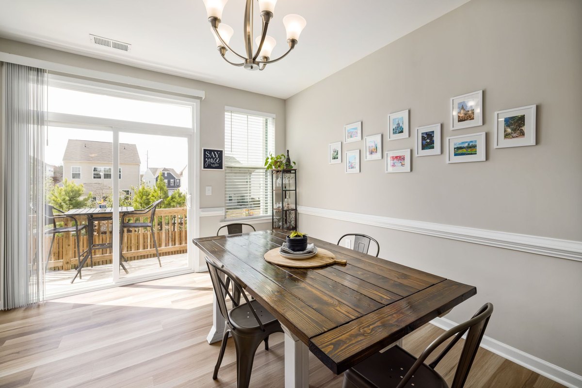 7 Best Real Estate Photo Editing Services in 2026 A bright, modern dining room with large windows showing a balanced exposure between the sunlit exterior and interior.